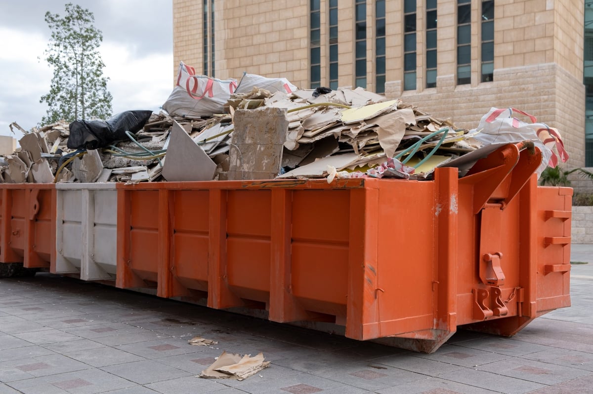 Overloaded dumpster filled with construction waste and rubble