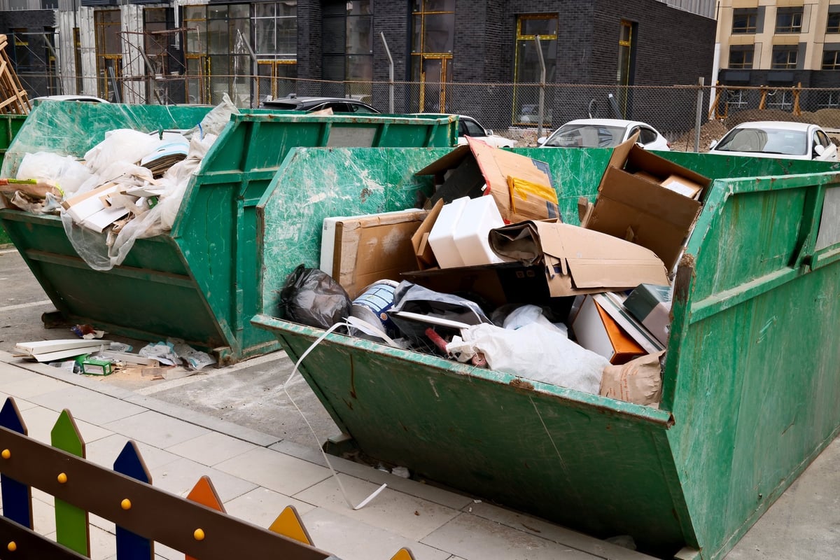 Construction dumpster filled with cardboard boxes and building waste